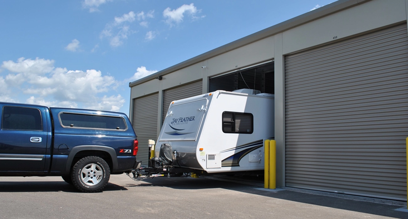 truck backing camper into storage unit