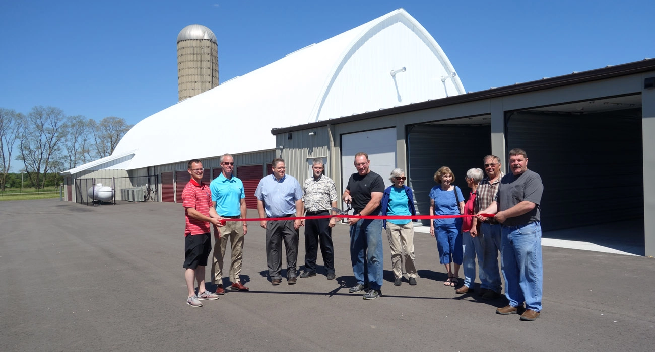 group of people cutting ribbon in ceremony